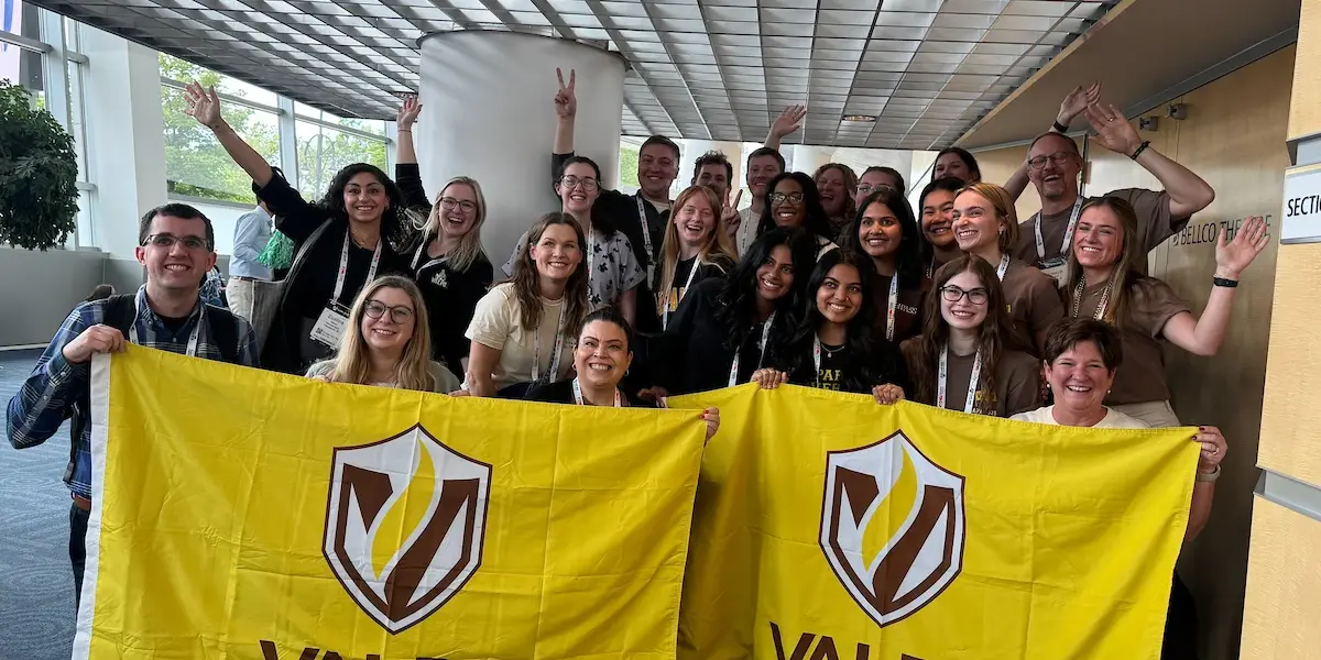 A group of students posing with 2 Valpo flags