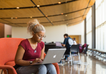 Woman seated working on a laptop